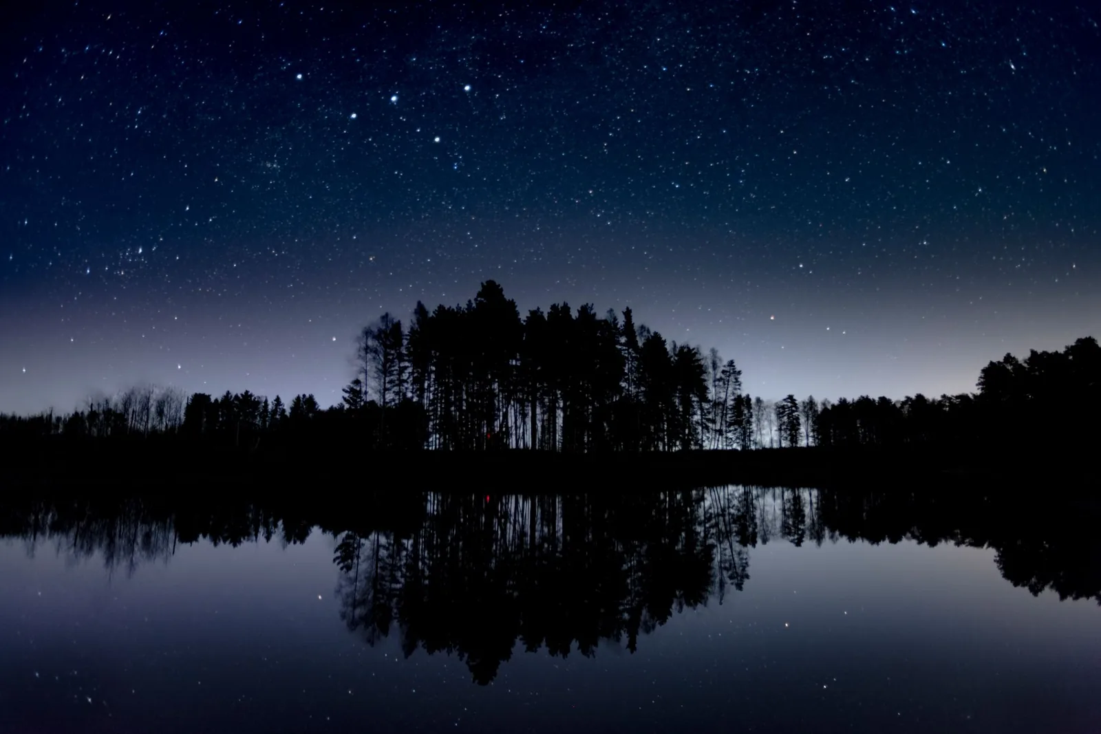 Tähtitaivas järven ja saaren yllä